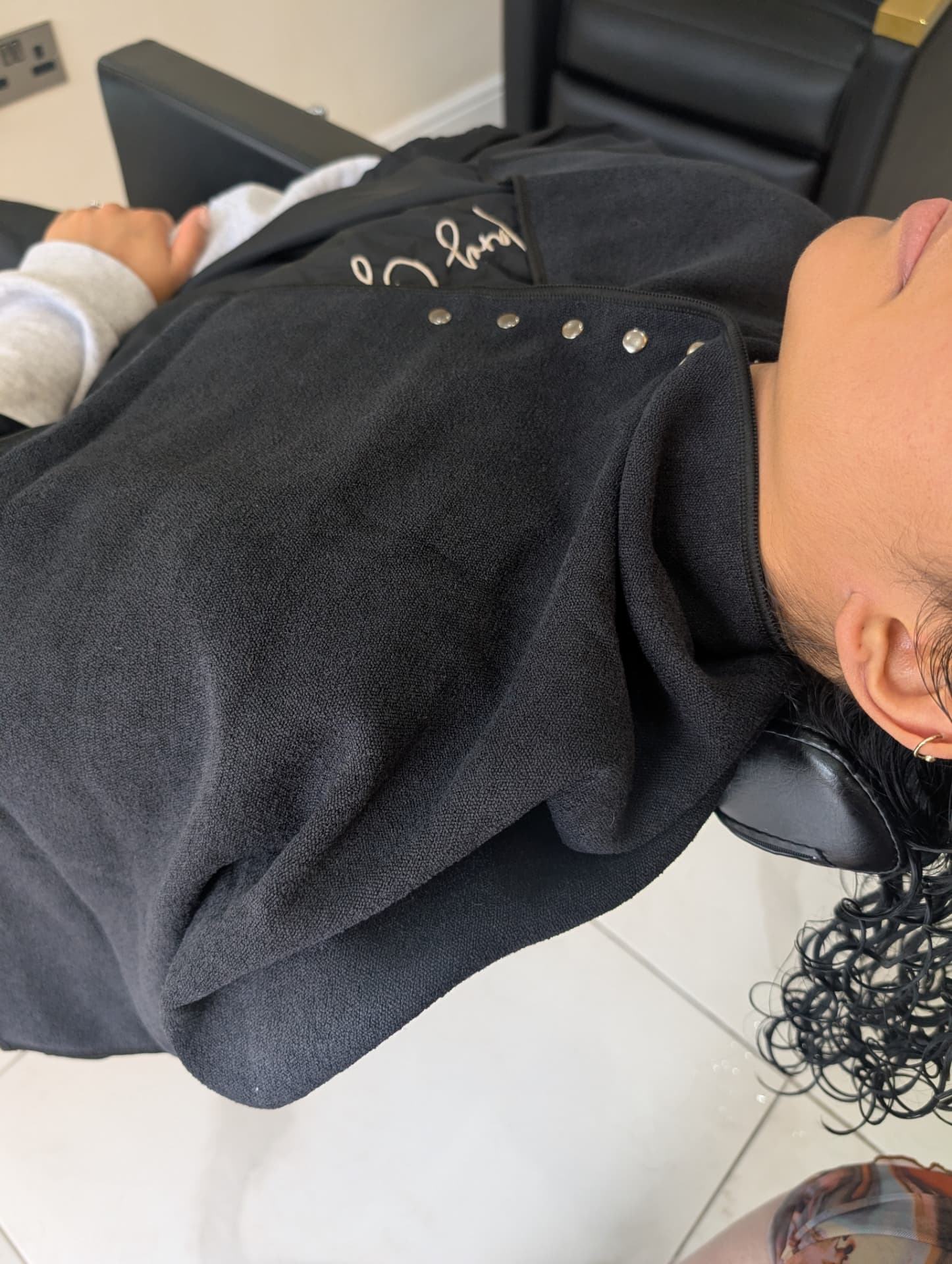 IMMY Towel fastened at the neckline with silver press studs while wet curls rest on top