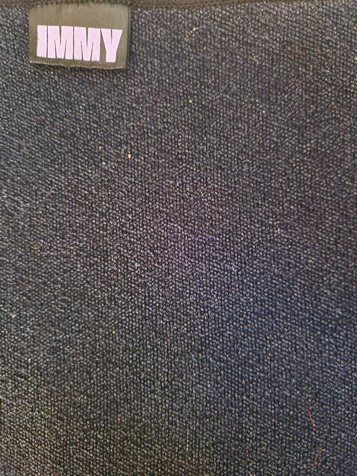 Close-up of the smooth charcoal microfiber and lilac IMMY label